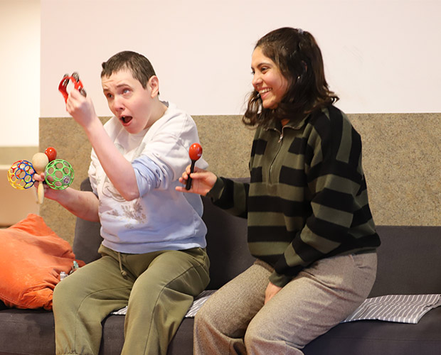 Junge und Frau sitzen auf einem Sofa und spielen zusammen