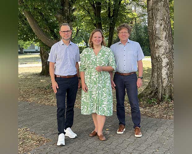 Gruppenbild 3 Personen Stehen im Grünen Und Lecken in die Kamera 2 Männer waren eine Frau